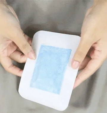 Hands holding a white adhesive foot pad, a different kind of product